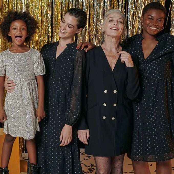 Trois femmes habillées en noire et une petite fille en robe à paillettes